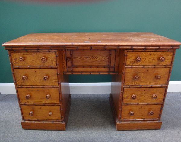 Howard & Sons, a 19th century pitch pine writing desk with eight pedestal drawers, mounted with faux split bamboo decoration, stamped 'Howard & Sons B