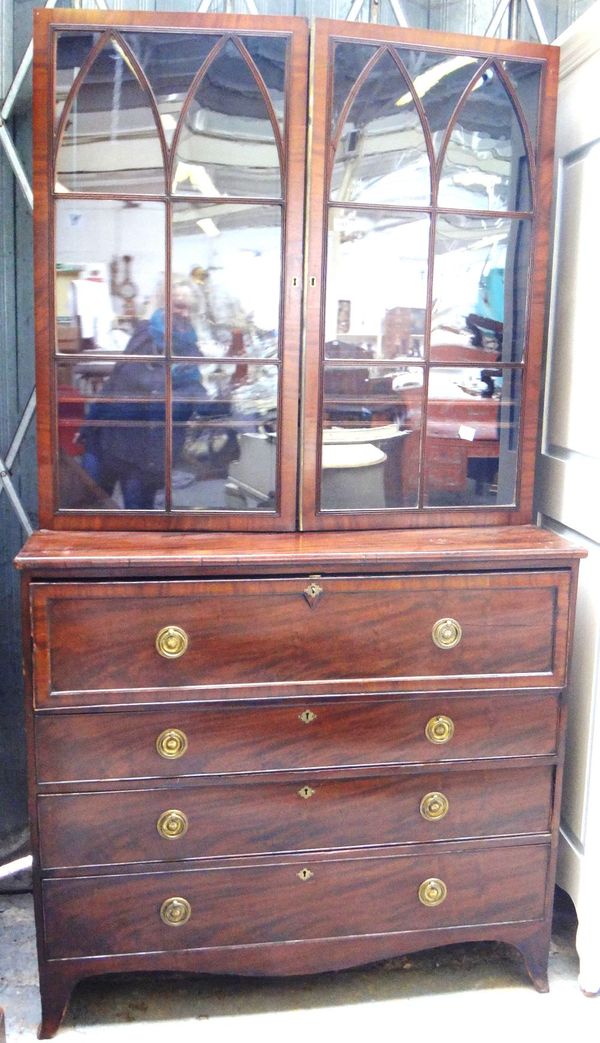 A George III mahogany secretaire chest, the pair of Gothic arch astragal glazed doors, over fitted drawer and three further long drawers, on splayed b