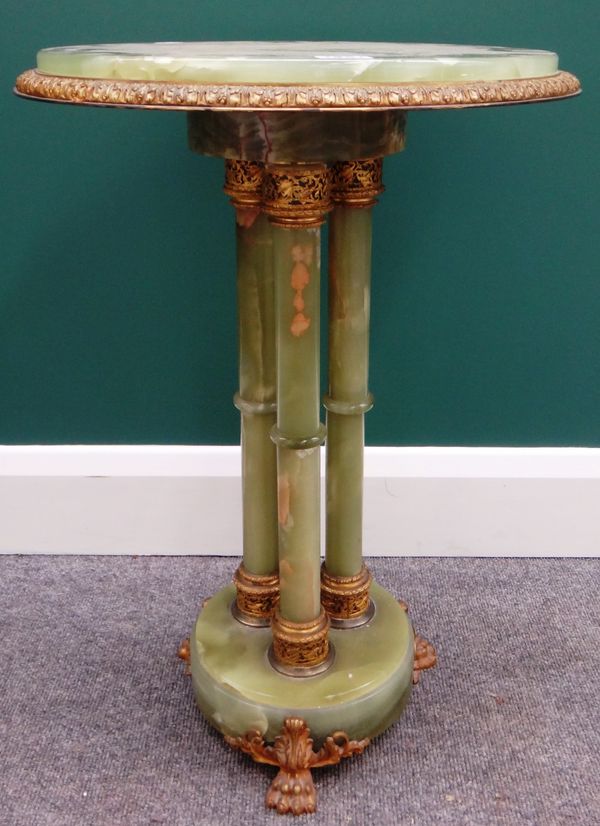 An early 20th century gilt metal mounted onyx circular occasional table on three turned supports and lions paw feet, 42cm wide.