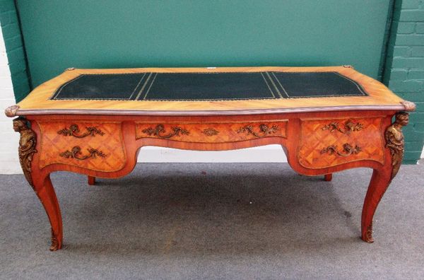 A Louise XV style gilt metal mounted walnut bureau plat, with shaped top over a bombe base, with five drawers about the knee and dummy verso, on four