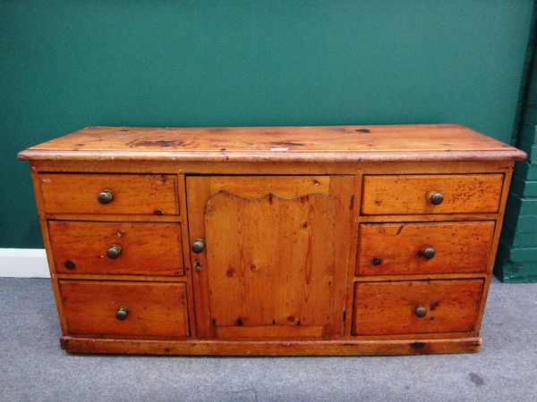 A 19th century pine dresser base, the central panel cupboard flanked by three graduated drawers to each side, 152cm wide.