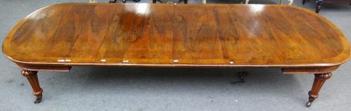 A Victorian oak banded walnut oval extending dining table, on tapering fluted supports, with five extra leaves, 132cm wide x 166cm long, 373cm fully e