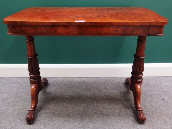 A 19th century figured mahogany rectangular centre table, with flush fit frieze drawer, raised on a pair of lappet carved columns and four downswept s