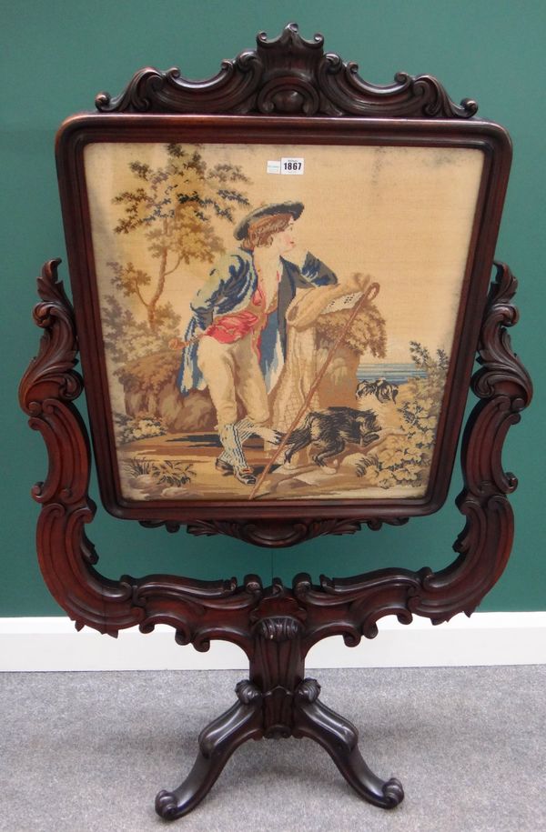 A Victorian rosewood firescreen with swing frame tapestry panel, on elaborately carved frame and tripod base, 87cm wide.