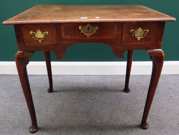 A mid-18th century mahogany banded oak lowboy, with three frieze drawers on slender cabriole supports, 80cm wide.