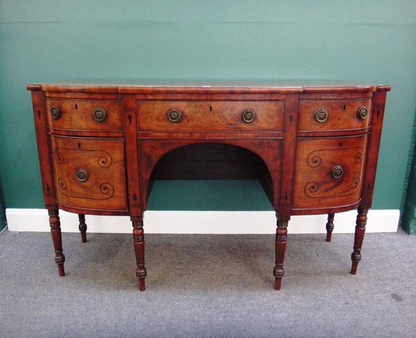 A Regency mahogany bowfront sideboard, with three frieze drawers and a pair of cupboards on turned supports, 152cm wide.