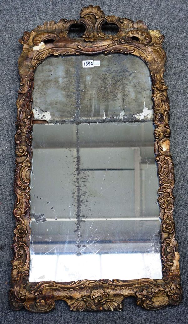 An 18th century gilt framed wall mirror, with pierced and carved frame about the two part mirror plate, 42cm wide x 87cm high.