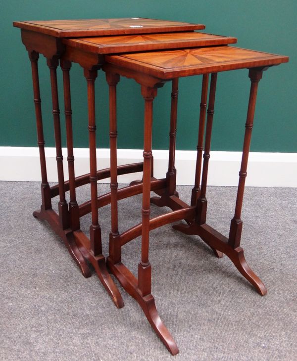 A nest of three mahogany early 20th century occasional tables with stellar veneered tops and ring turned supports, the largest 44cm wide.