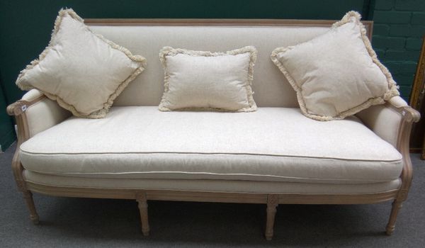 A Louis XVI sofa, the distressed grey painted frame and cream upholstery on tapering fluted supports, 190cm wide.