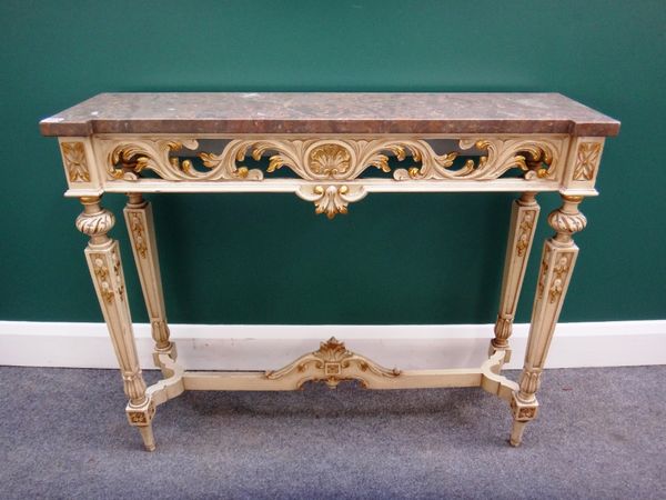 A 20th century console table, the inverted breakfront marble top on a cream and parcel gilt painted, pierced and carved base, on tapering square suppo