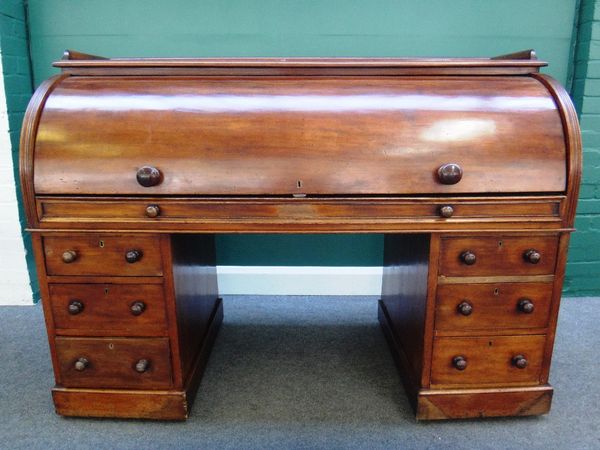 A 19th century mahogany cylinder pedestal desk, with fitted pull-out writing interior, over six pedestal drawers on a plinth base, 151cm wide.