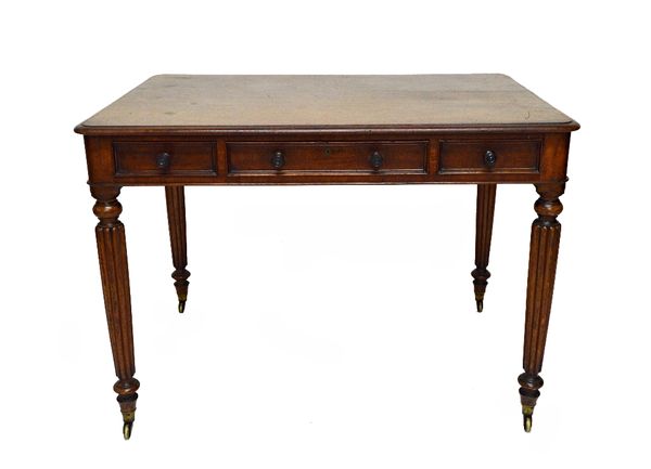 A George IV writing table with three frieze drawers and dummy verso, on tapering reeded supports, 108cm wide.   Illustrated