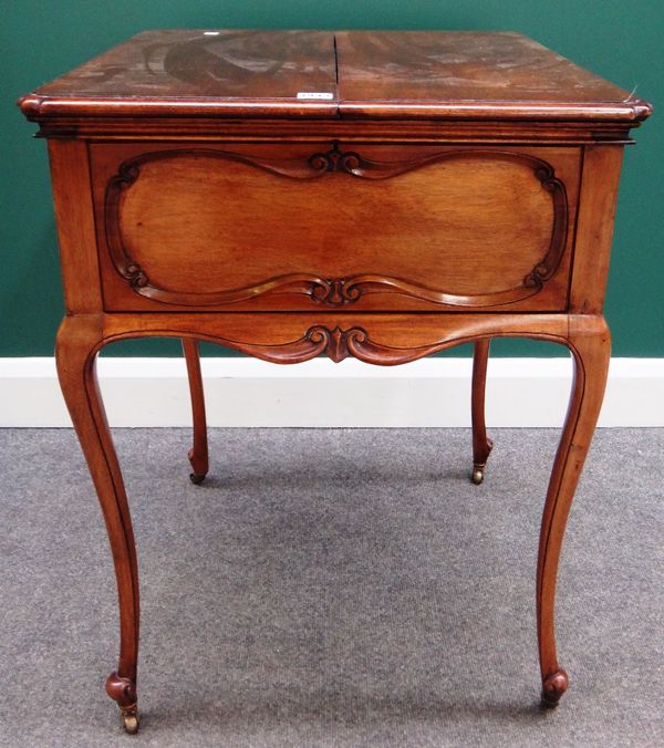 An early 20th century mahogany writing table, the double lift top with pop-up fitted interior, on four cabriole supports, the lacquered brass hinges s