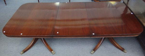 A Regency style mahogany twin pillar extending dining table, on eight downswept supports, one extra leaf, 115cm wide x 180cm long x 240cm long fully e