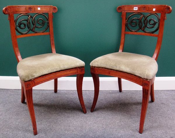 A pair of 19th century walnut framed side chairs, with green painted interlaced serpent splat and concave seat, on sabre supports.