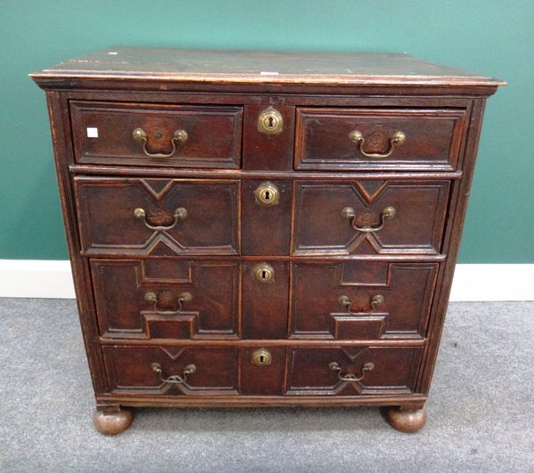 A Charles II oak geometric moulded chest of two short and three long graduated drawers on bun feet, 86cm wide.