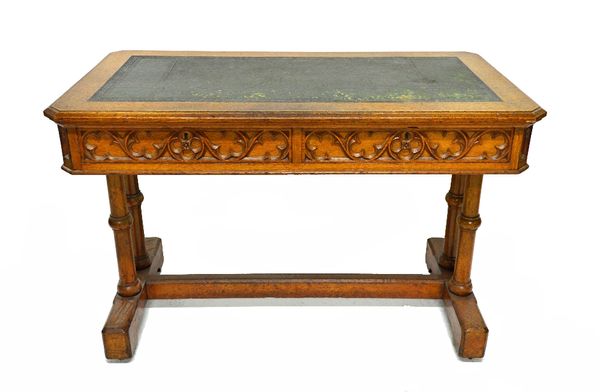 Bulstrode of Cambridge; a Victorian oak Gothic Revival centre table, the canted rectangular leather inset top over a blind Gothic tracery frieze with