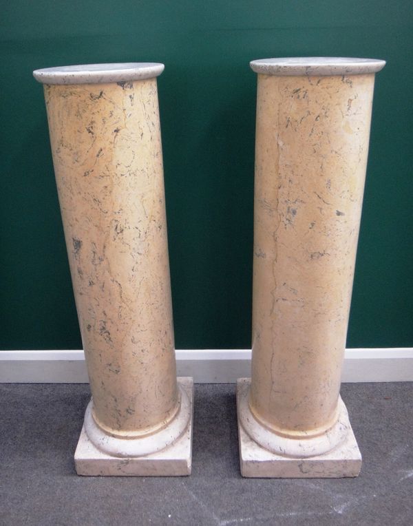 A pair of late 19th/early 20th century composite marble columns, with gun barrel bodies on square bases, 115cm high.