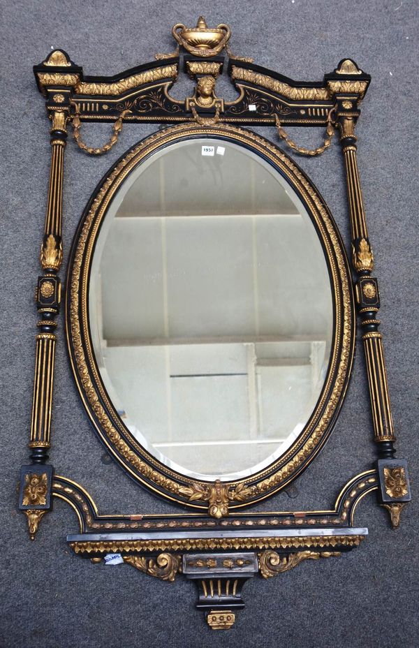 A 19th century ebonised parcel gilt wall mirror with urn crest above bevelled oval plate, flanked by fluted columns 84cm wide x 158cm high.