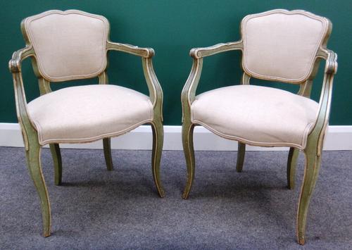 A pair of green painted Louis XV style open arm fauteuils, with serpentine seat and cabriole supports.