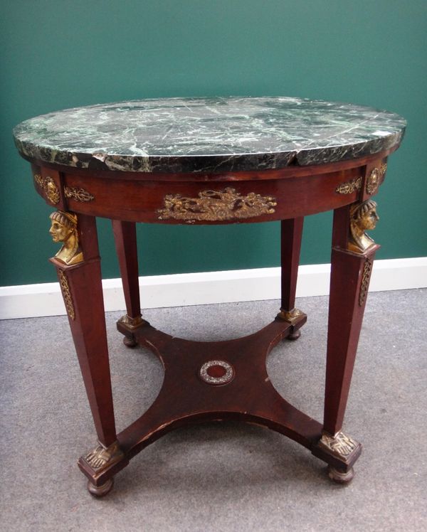 An Empire design centre table, the circular marble top on a gilt metal mounted mahogany base, with four tapering square supports, with caryatid mounts