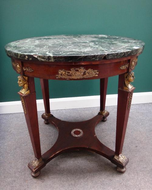 An Empire design centre table, the circular marble top on a gilt metal mounted mahogany base, with four tapering square supports, with caryatid mounts