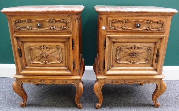 A pair of 20th century bedside tables, each with marble top over a bleached carved oak base, with single drawer over cupboard, on cabriole supports, 4