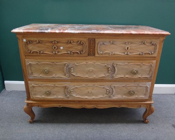 An early 20th century Continental commode, the marble top over a carved bleached oak base with two short and two long drawers, on scroll feet, 130cm w