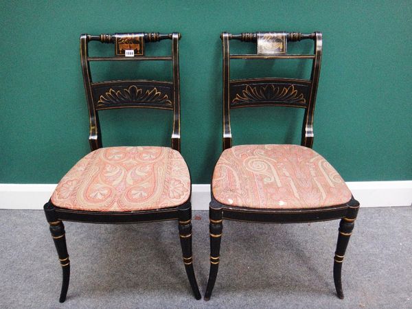 A set of four black lacquer parcel gilt Regency dining chairs with turned tablet centred waist rail and bow seat on turned splayed supports, (a.f.).