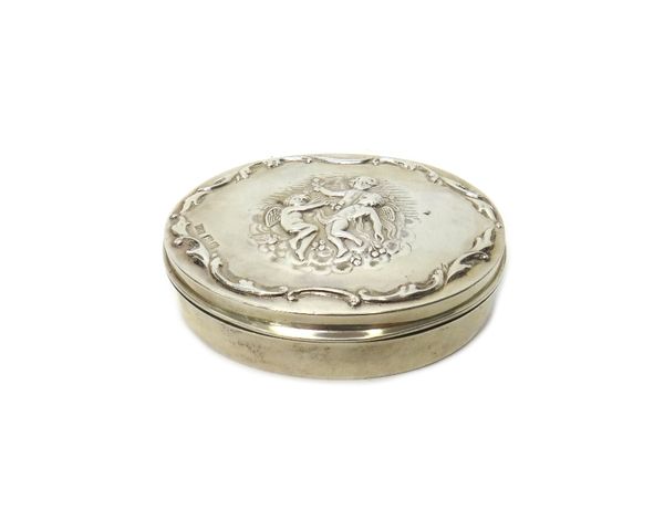 A silver oval hinge lidded trinket box, the cover decorated with three dancing cherubs within a border of scrolls, by Mappin and Webb London 1903, wei