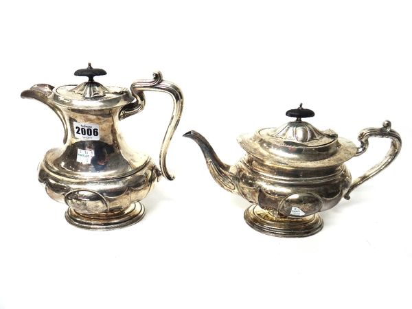 A silver hot water jug and a similar silver teapot, each of panelled oval form, with ebony finials, the hot water jug, London 1919, the teapot London