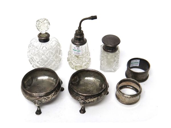 Silver and silver mounted glass wares, comprising; a pair of George II circular salts, each raised on three feet, London 1757, two napkin rings, a sme