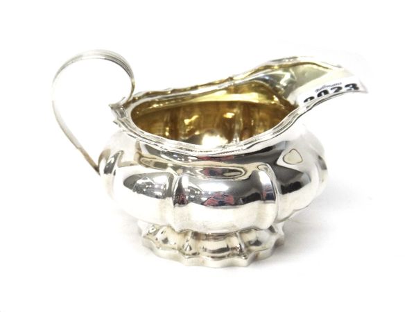 A George IV silver milk jug, of compressed shaped circular form, with panelled decoration and on a shaped circular foot, London 1824, weight 220 gms.