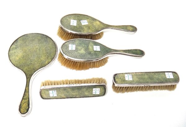 A lady's silver and shagreen mounted five piece part dressing set, comprising; a hand mirror, two hairbrushes and two clothes brushes, Birmingham 1924