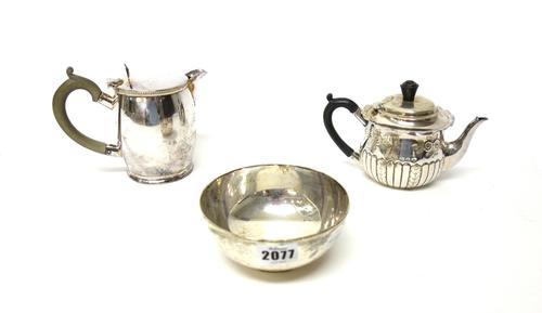 A Victorian silver teapot, decorated with floral panels above partly fluted decoration, Birmingham 1894, with black fittings, a silver sugar bowl, of