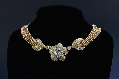 A gold and diamond floral necklace, the principal transition cut diamond weighing 3.88 cts centred within a flowerhead design, set with 95 round brill