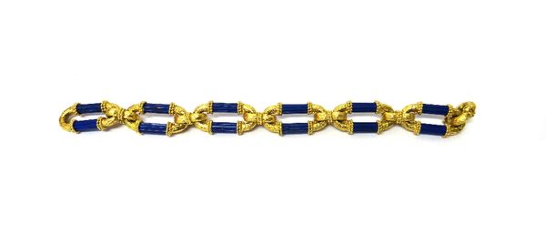 A gold and lapis lazuli bracelet, each oval link formed as a pair of lapis lazuli fluted batons, otherwise with a bark textured finish and with beaded