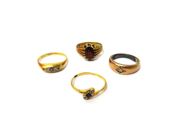 A 9ct gold ring, claw set with an oval cut garnet, a diamond set single stone ring, a sapphire and diamond set three stone ring, in a crossover design