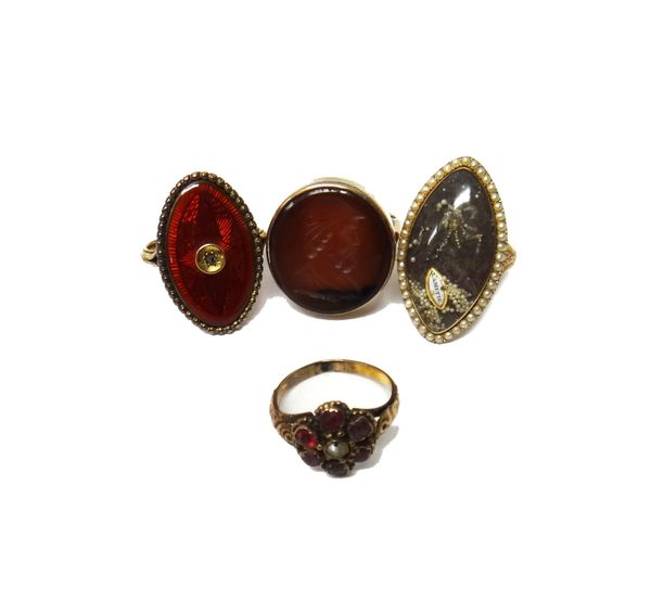 A gold ring, glazed with a navette shaped locket compartment at the centre, within a border of seed pearls and with engraved decoration to the shoulde