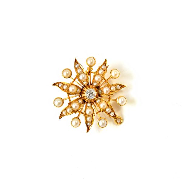 A gold, diamond and half pearl set pendant brooch, designed as a flowerhead, mounted with the cushion shaped diamond at the centre and otherwise mount