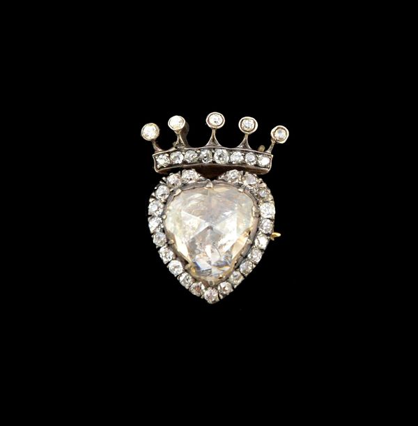 A diamond brooch, mounted with a large foil backed rose cut diamond to the centre, in a heart shaped surround set with small cushion shaped diamonds a