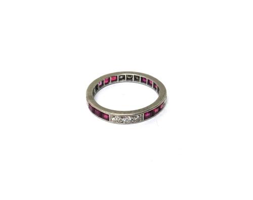 A diamond and ruby set full eternity ring, mounted with rows of three circular cut diamonds, alternating with rows of three calibre cut rubies, ring s