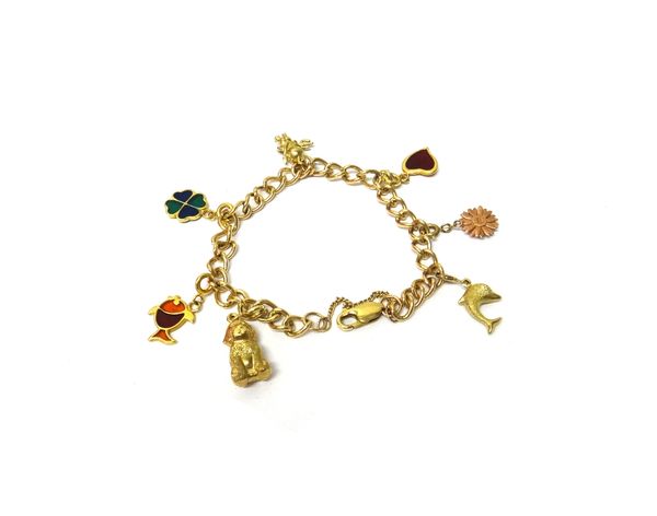 A 9ct gold curb link charm bracelet, fitted with three enamelled charms and with four further charms, including;  a dog, a dolphin and a fish, gross w