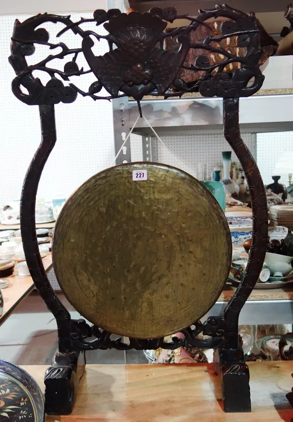 A hardwood Oriental gong stand with a bronze gong.