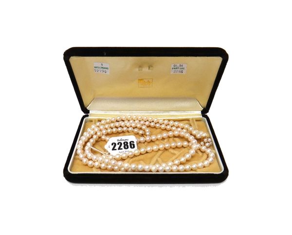 A two row necklace of uniform cultured pearls, on a gold and cultured pearl cluster clasp, detailed K 14, with a case, length 57.5cm.