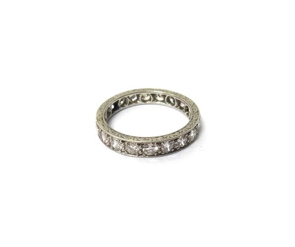 A platinum and diamond set full eternity ring, mounted with cushion shaped diamonds, the sides of the mount with scroll engraved decoration and detail