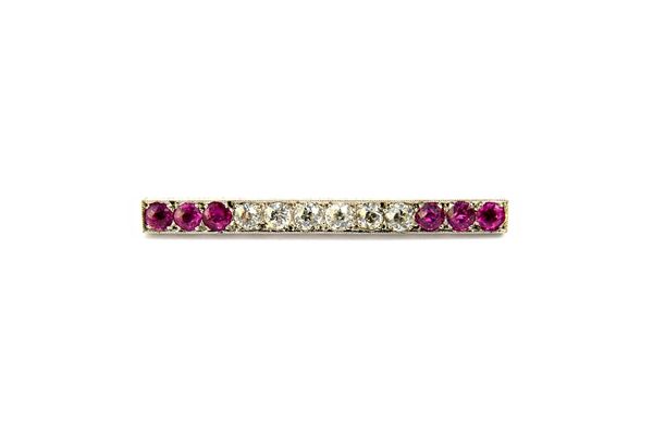 A diamond and pink sapphire set bar brooch, mounted with a row of six cushion shaped diamonds to the centre and with a row of three cushion shaped pin