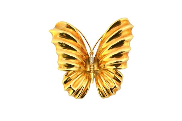 An Italian gold and diamond set brooch by Adler, designed as a butterfly in flight, detailed 750, gross weight 20.9 gms, wing span 6cm, with an Adler