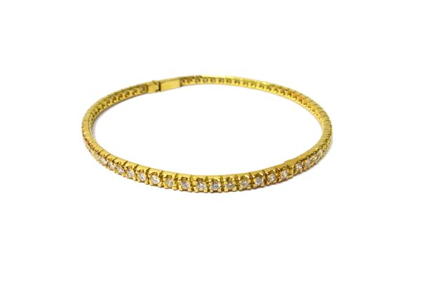 A gold and diamond set oval hinged bangle, mounted with a row of circular cut diamonds, on a snap clasp, gross weight 14.8 gms, with a case.