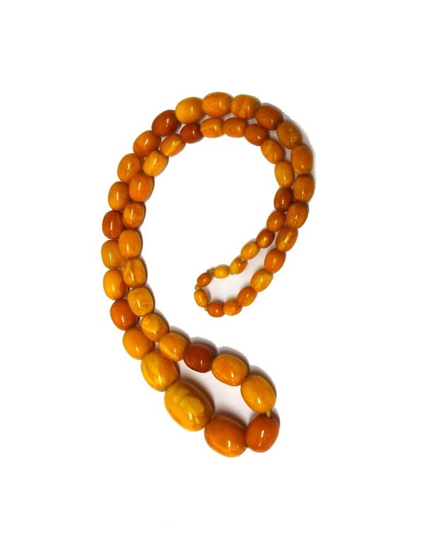 A single row necklace of graduated oval mottled vary coloured butterscotch coloured amber beads, gross weight of necklace 61 gms.